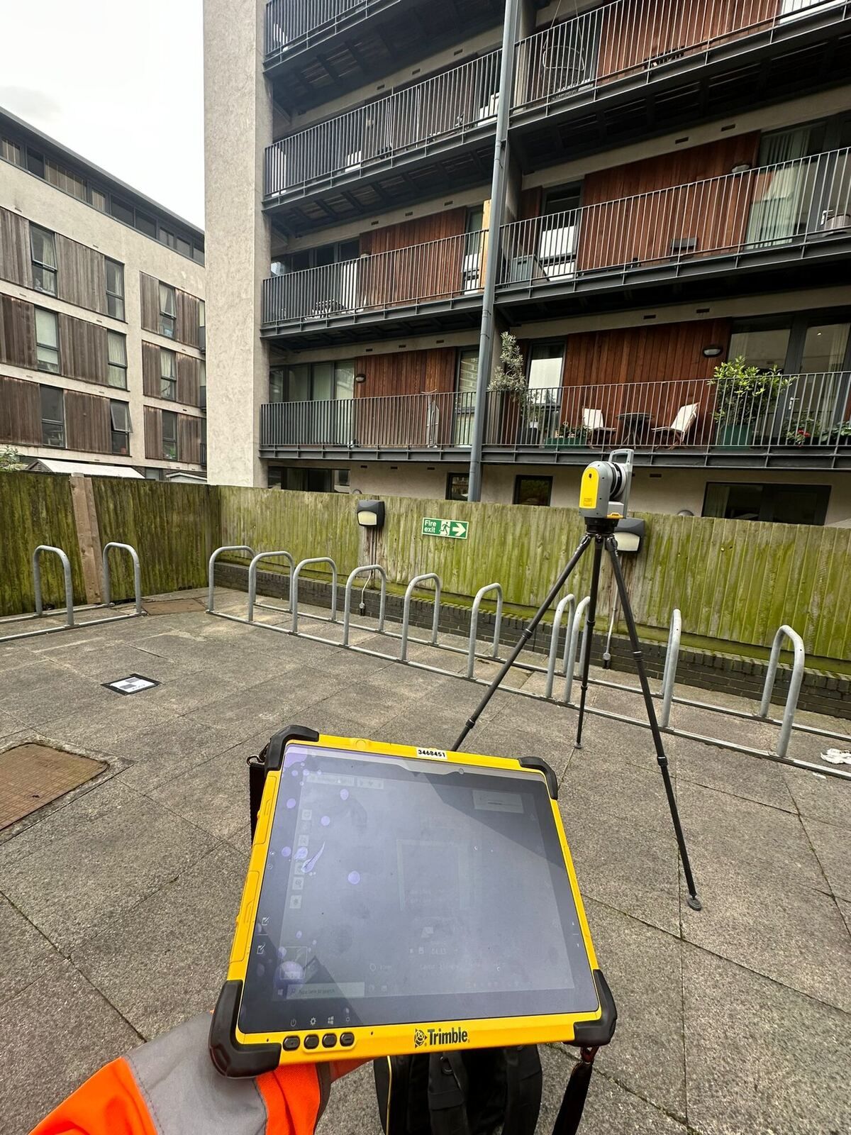 Robotic total station and controller set up in a residential courtyard