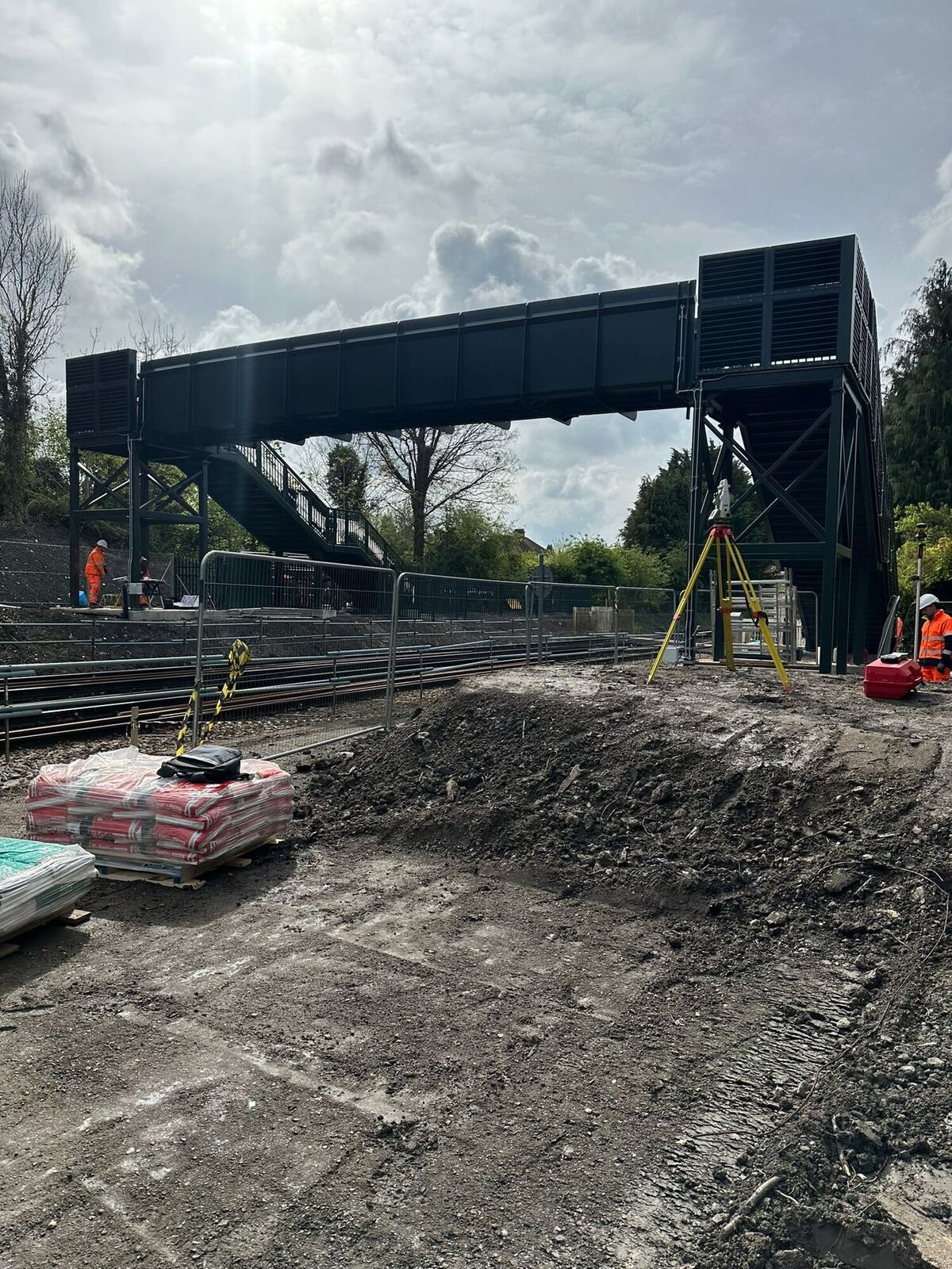 Survey station set up beside a railway footbridge under construction